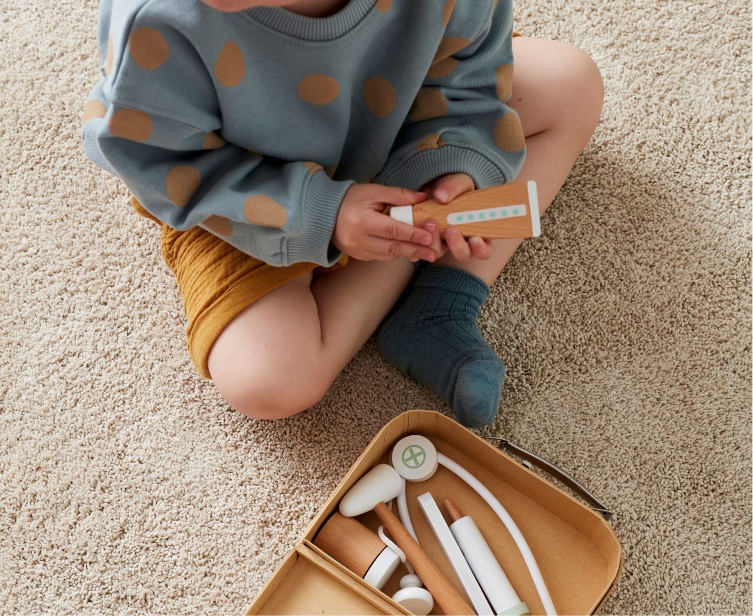 Enfant jouant avec une mallette de docteur en bois Kid's Concept – idée cadeau Noël bébé et jouet d’imitation