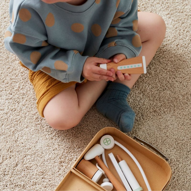 Enfant jouant avec une mallette de docteur en bois Kid's Concept – idée cadeau Noël bébé et jouet d’imitation