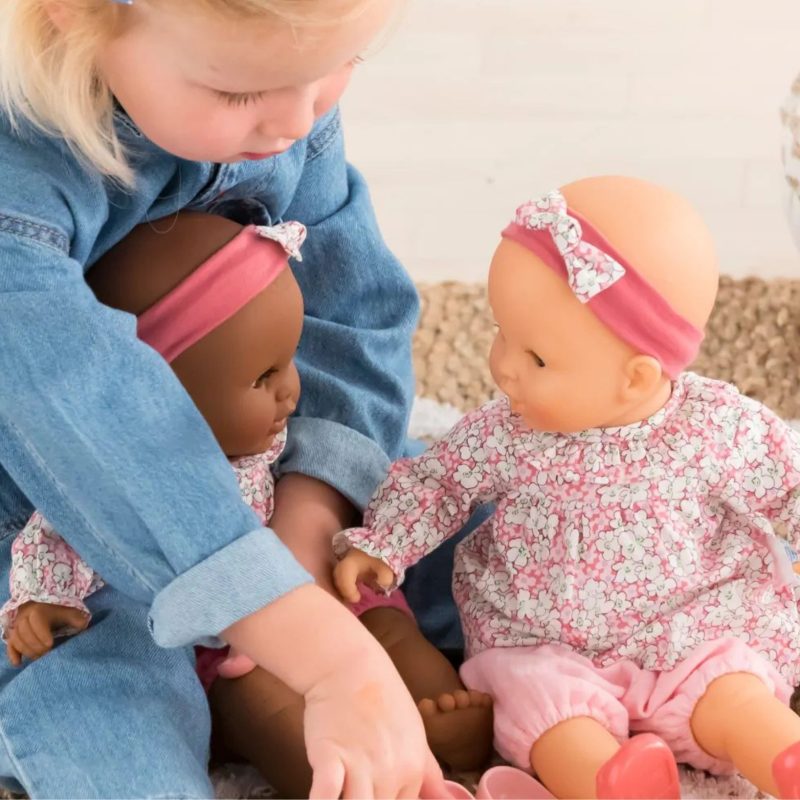Enfant jouant avec deux poupons Corolle habillés en rose, idée cadeau bébé Noël et jouet d’imitation pour les fêtes