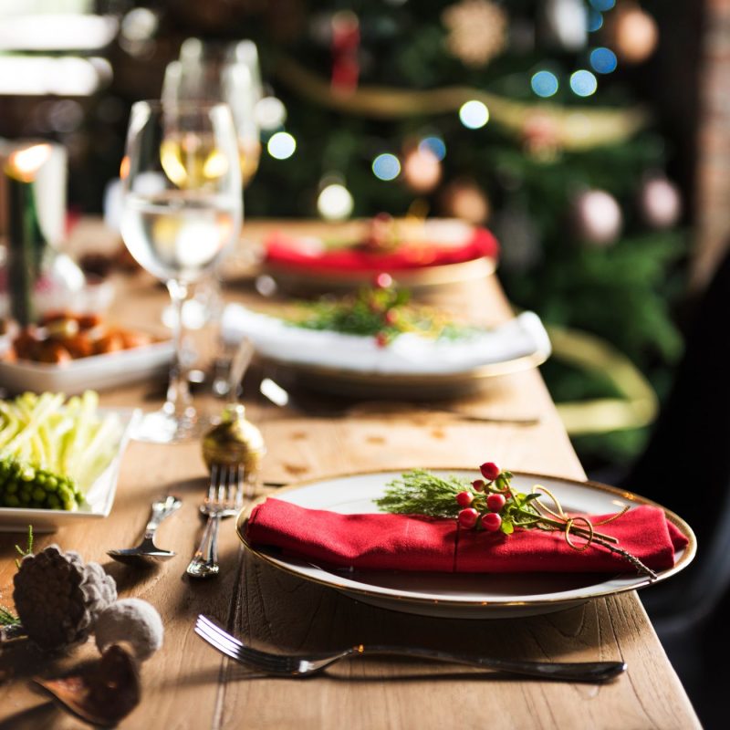 Table de Noël décorée avec assiettes, verres et décorations naturelles pour un repas femme enceinte Noël convivial et sécurisé.