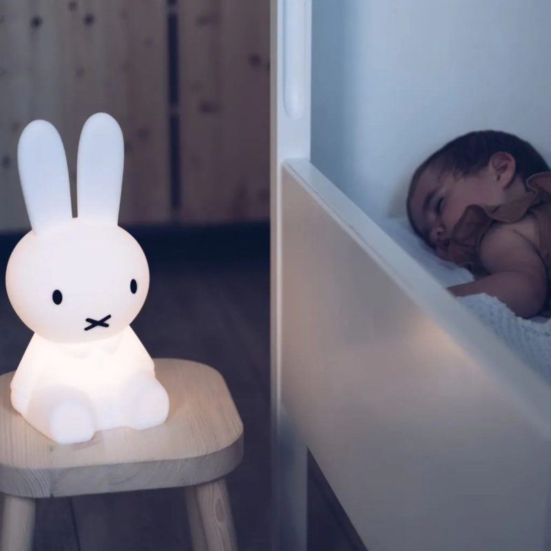 Veilleuse lapin allumée dans une chambre où un bébé dort paisiblement après une berceuse bébé.