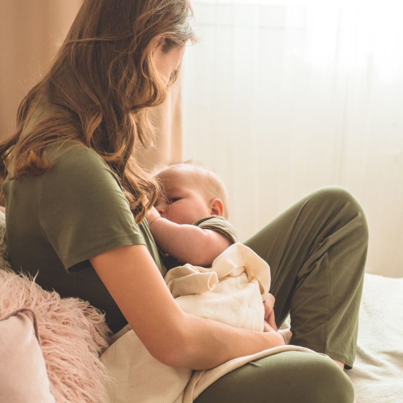 Maman allaitant son bébé au sein dans le cadre d’un allaitement mixte à la maison.
