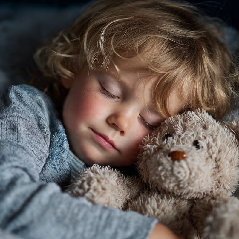 Enfant endormi avec un doudou dans son lit, image illustrant la terreur nocturne et le sommeil apaisé.