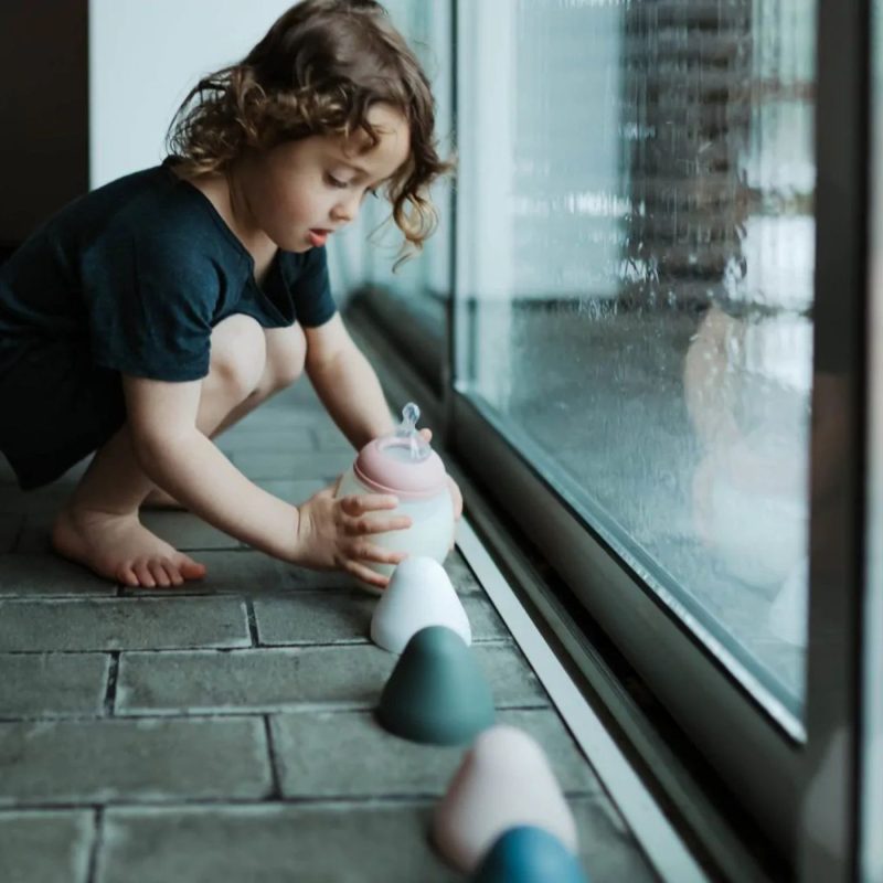 bébé avec biberon illustrant la quantite de lait bebe selon l’âge