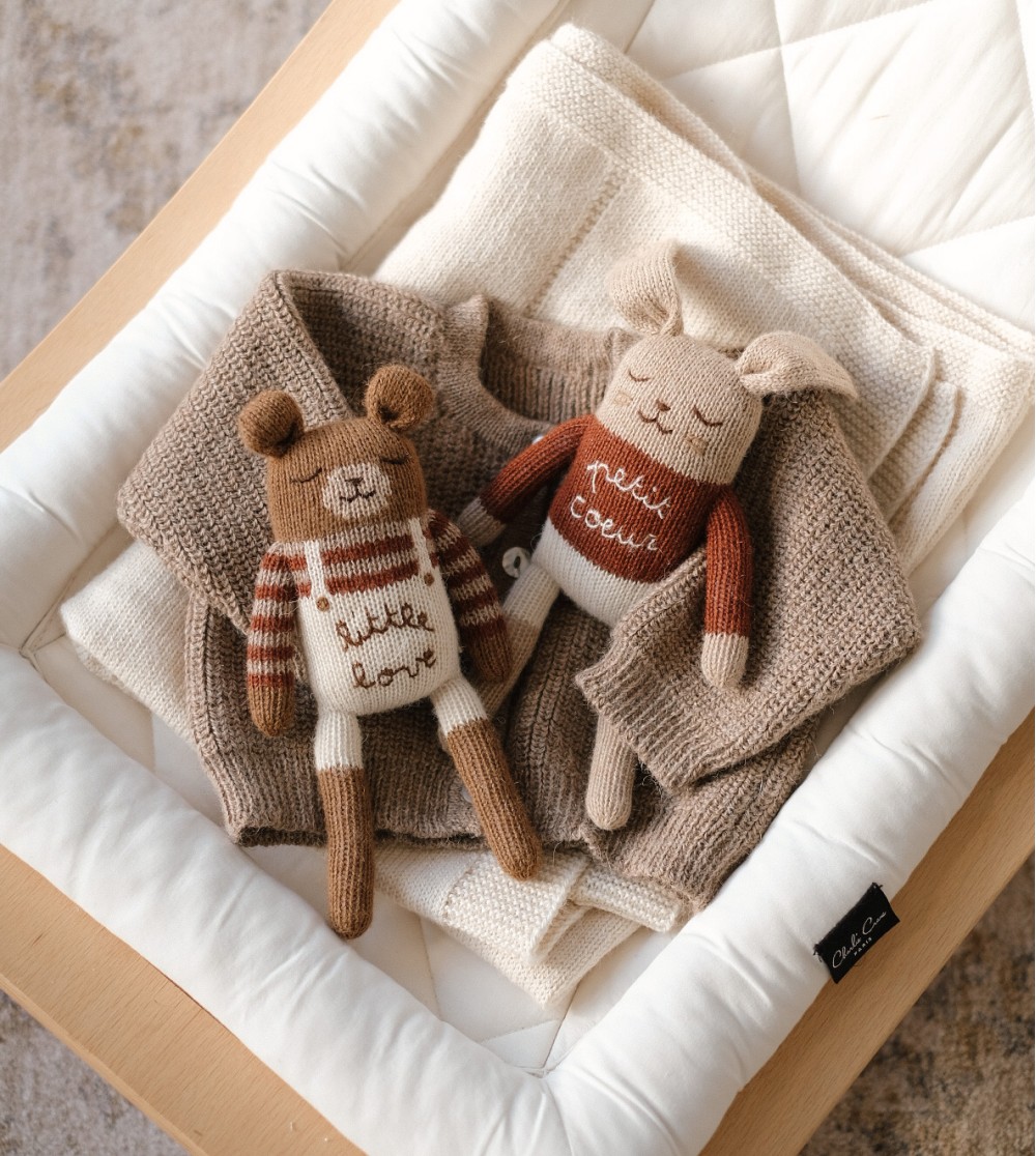 Doudou nouveau né en laine lapin petit cœur dans un couffin, jouet doux dès la naissance.