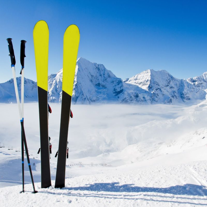 Skis posés dans la neige en station de ski avec vue sur la montagne enneigée